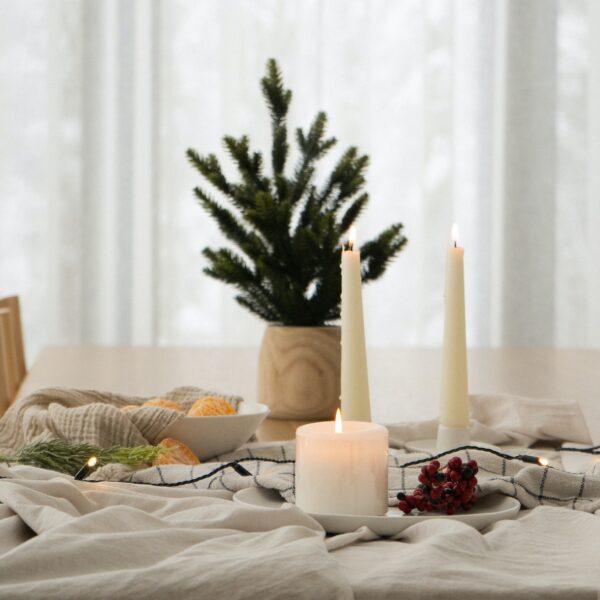 a table topped with candles and a bowl of fruit